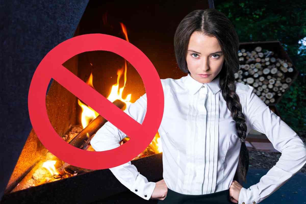 donna arrabbiata davanti a un camino e il simbolo di un divieto