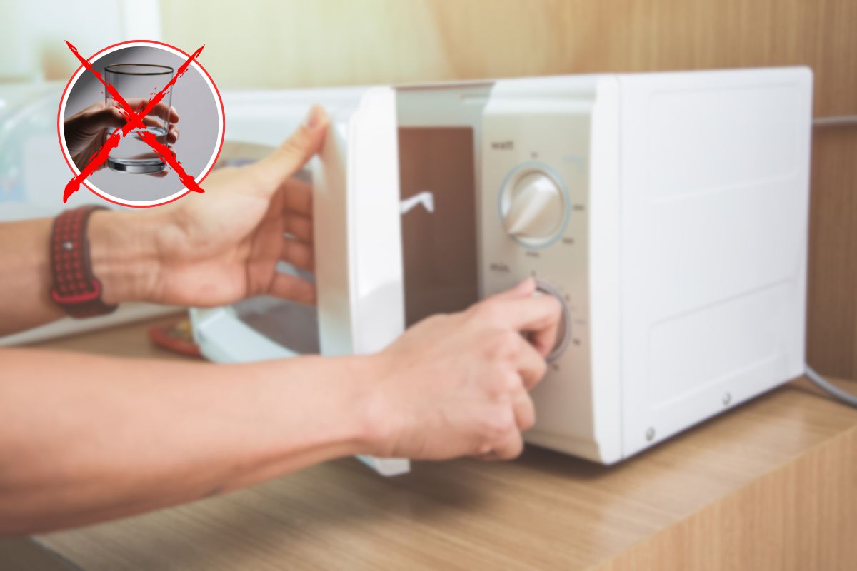 donna aziona microonde ed x rossa su bicchiere di acqua