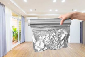 mano che mantiene rotolo di carta stagnola in un grande salotto