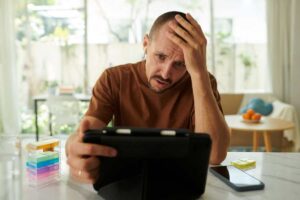 uomo disperato con tablet in mano