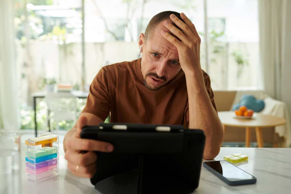 uomo disperato con tablet in mano