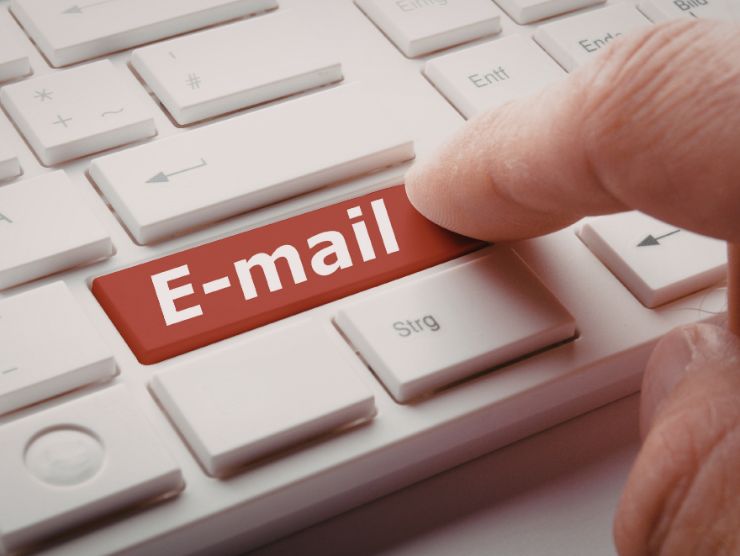 mano digita mail sulla tastiera del pc