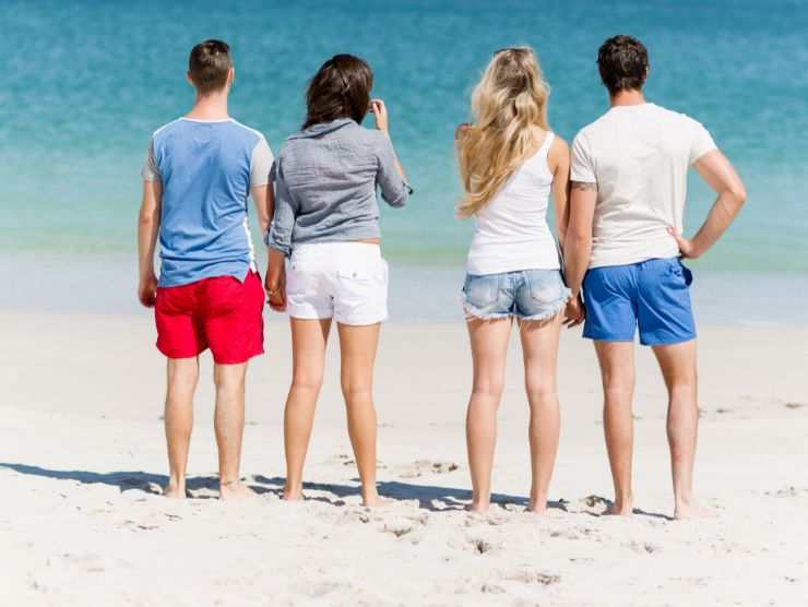 persone di spalle al mare